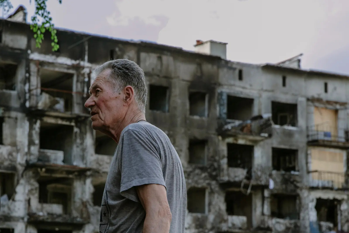 Man in front of a destroyed home in Ukraine